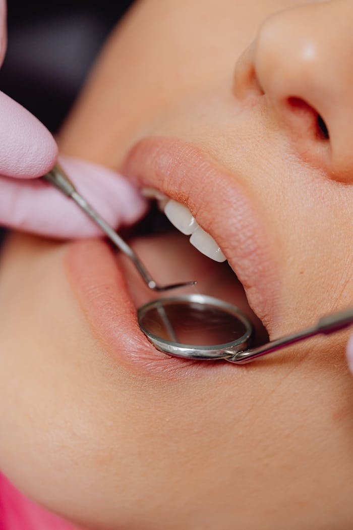 Close-up view of a patients dental check-up using dental mirror and tools.